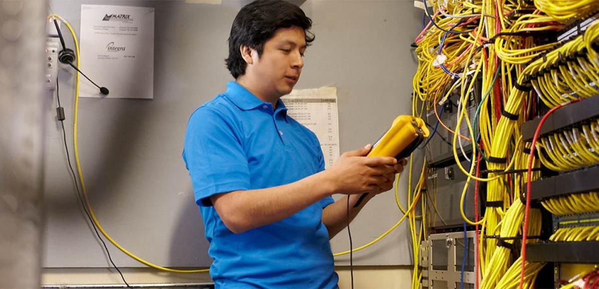 Student performing maintenance in the server room at Minneapolis College