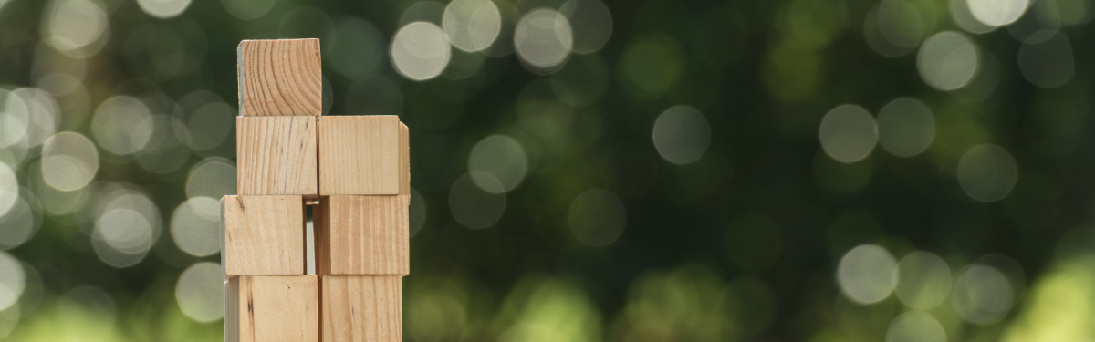 Stacked wooden blocks over green light showing background 