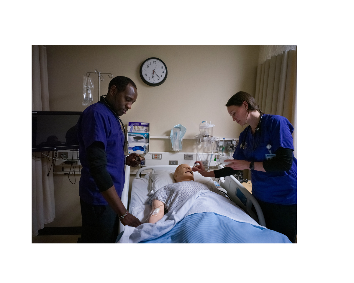 two nursing students working on mannequin patient