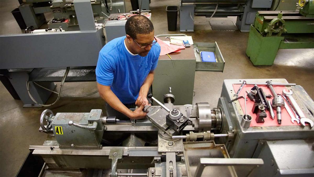 Train For a Career at Minneapolis College Student working a lathe in a machine shop