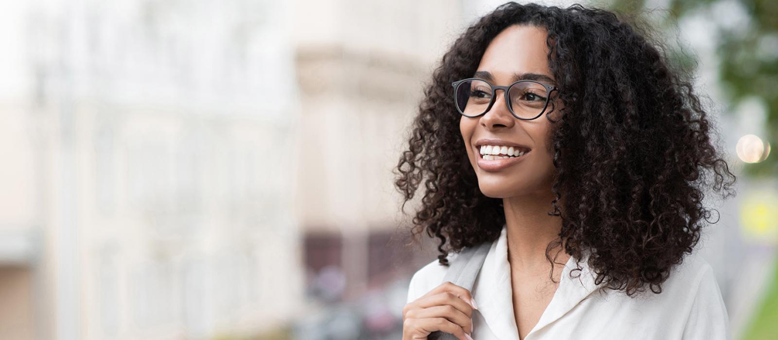 A smiling student walking on campus. 