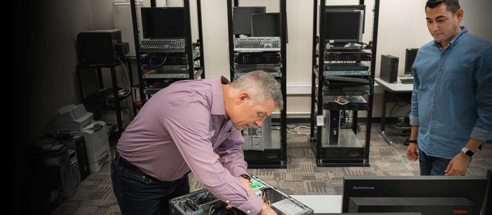Minneapolis.edu Insructor working on an opened computer while student watches