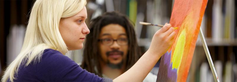 Minneapolis College Art Student with Instructor student painting in front of the instructor