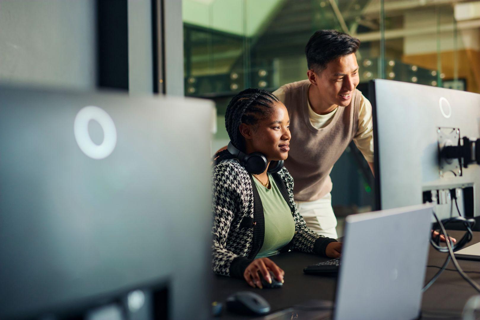 A man and a woman look at a computer screen together