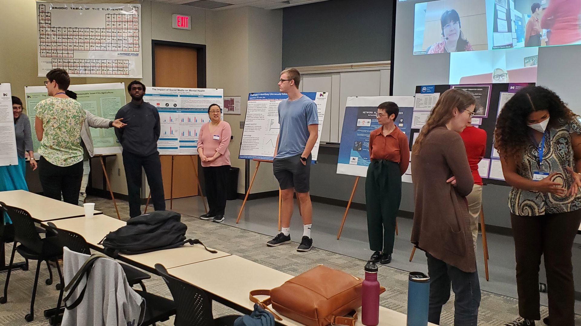 Students presenting research in a classroom with posters in the background