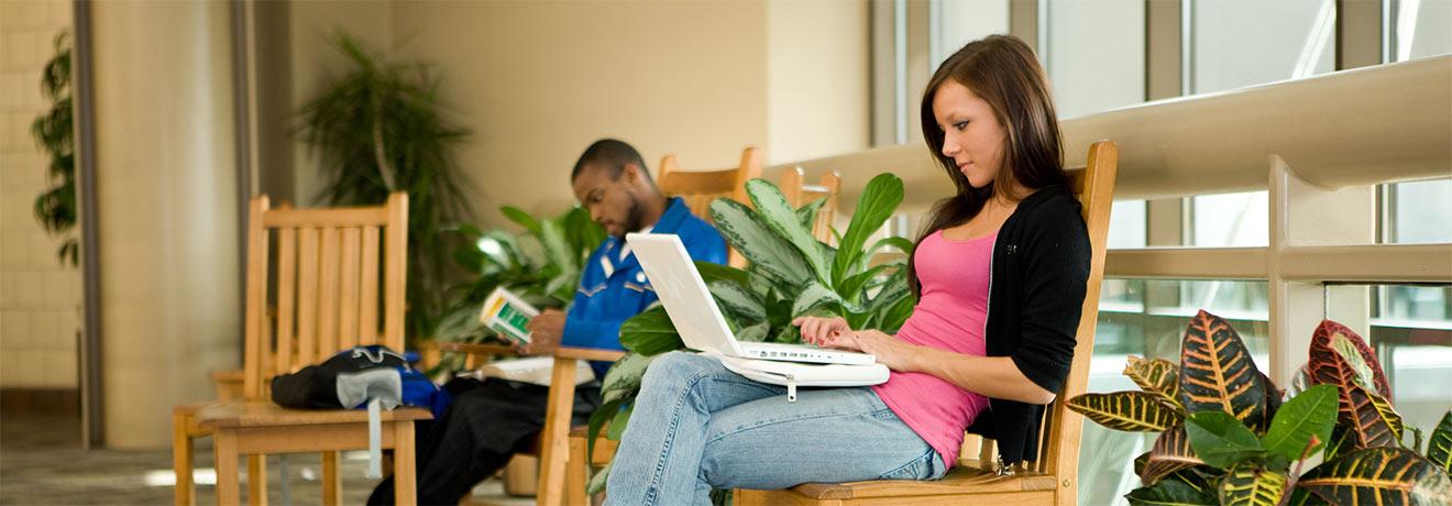 Two students sitting in chairs, studying