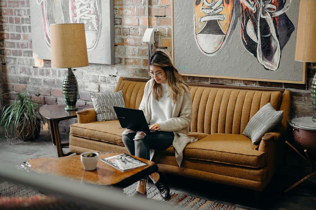 woman sitting on couch with computer