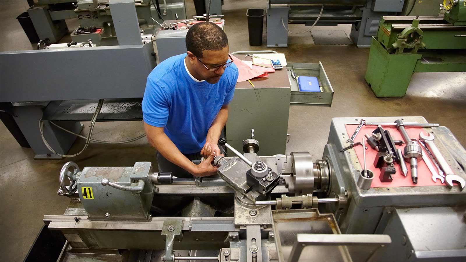 Student working a lathe in a machine shop