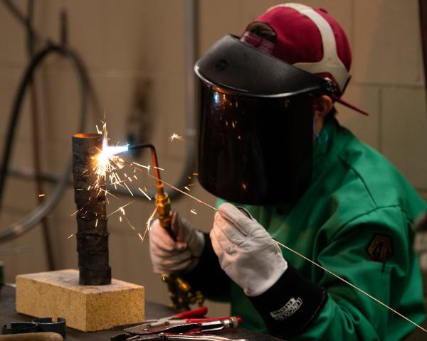 Woman welding with sparks 