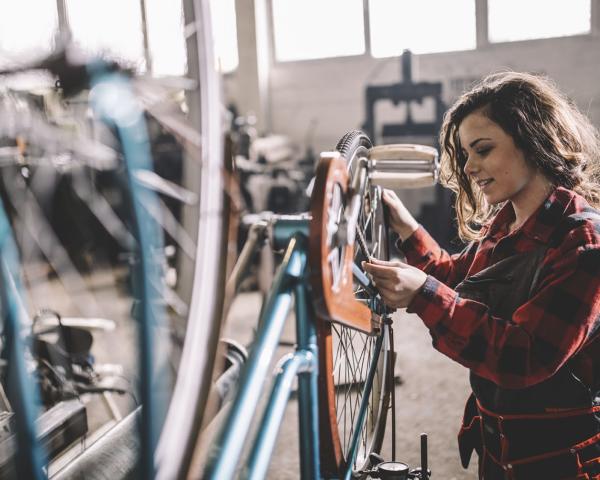 Woman fixing bike inside a bike shop
