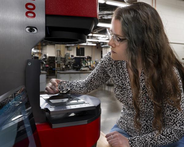 Woman looking closely at something at a machine 
