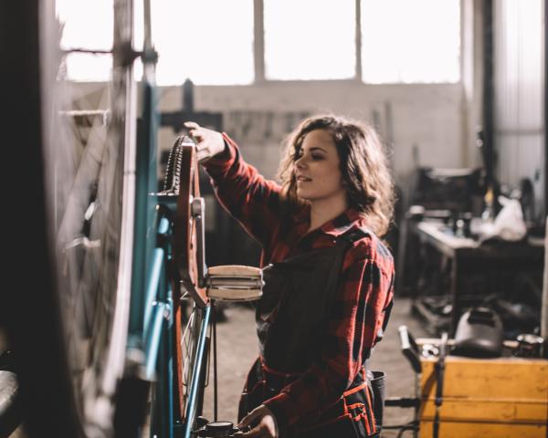 Woman fixing a bike in a garage 