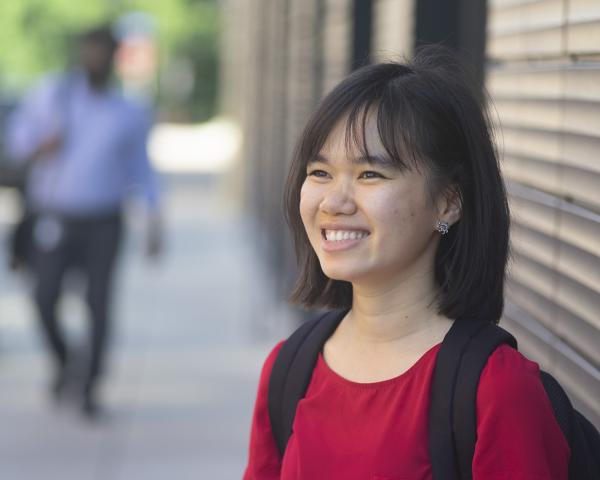 student on sidewalk smiling