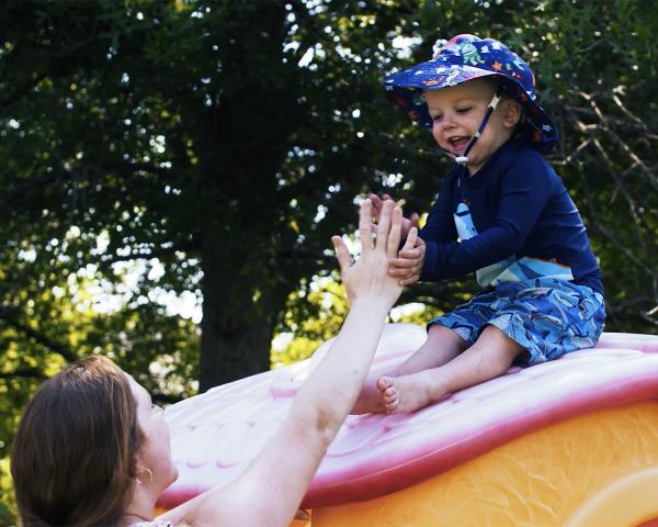 woman and toddler playing on slide
