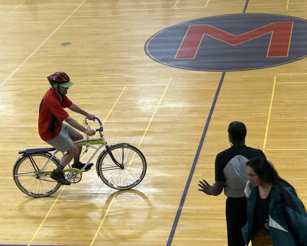 person riding bike on a basketball court