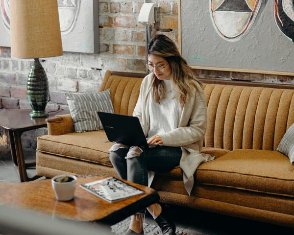 woman on couch using her laptop