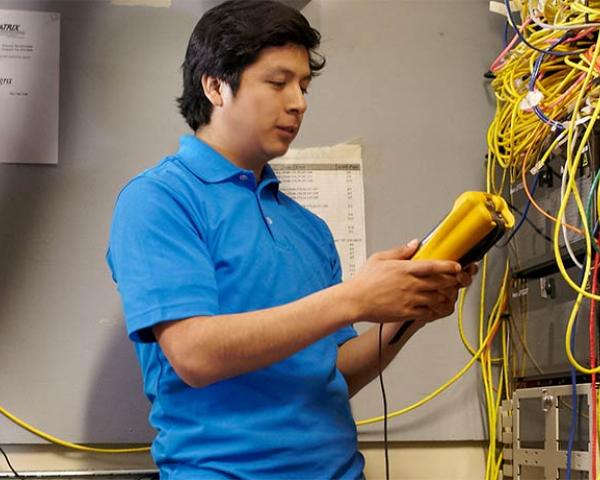 The School of Information Technology at Minneapolis College Student performing maintenance in the server room at Minneapolis College