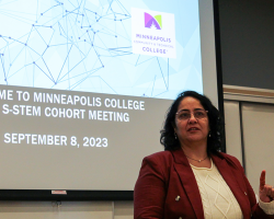 dr kumar speaking in front of a projection