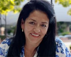 A portrait of Maria Tobalina outdoors, smiling. 