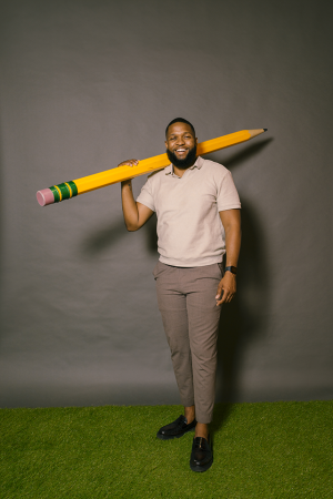 man standing with giant pencil on his shoulder