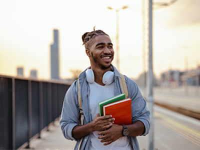 Man walking on a bridge with school books