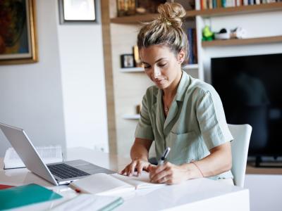 Woman at home working at her desk and with a laptop 