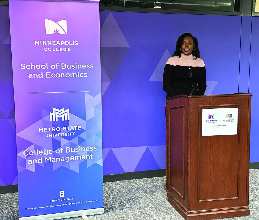 Student at podium with sign to her left that says School of Business and Economics 